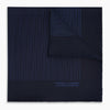 View 1 of product The Navy Stripe Silk Pocket Square by Turnbull & Asser features a dark navy silk with thin light blue stripes and hand-rolled edges, folded to reveal both sides and “TURNBULL & ASSER HAND PRINTED IN ENGLAND” in the corner.