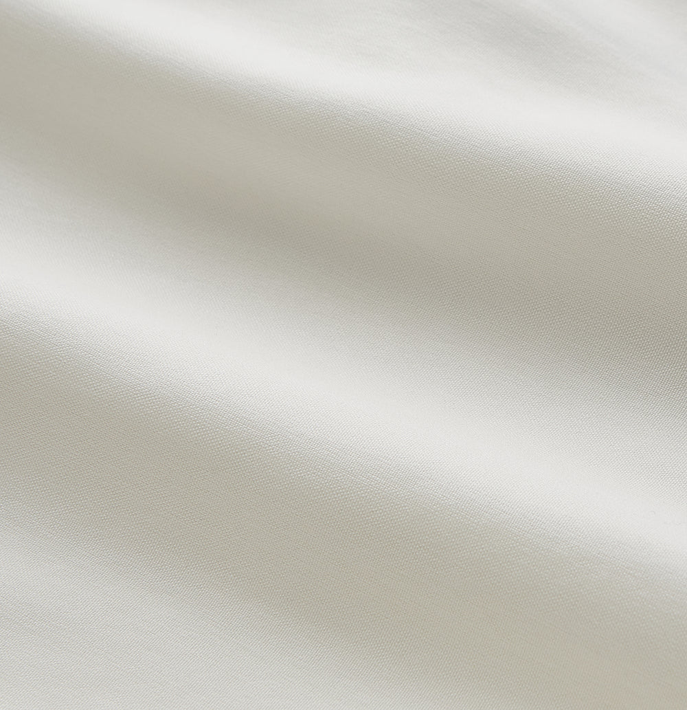 The Women's Harriet Cream Silk Pyjama Set by Turnbull & Asser features a white sand-washed silk button-up top with black piping and chest pocket, plus matching drawstring pants, all shown against a white background.