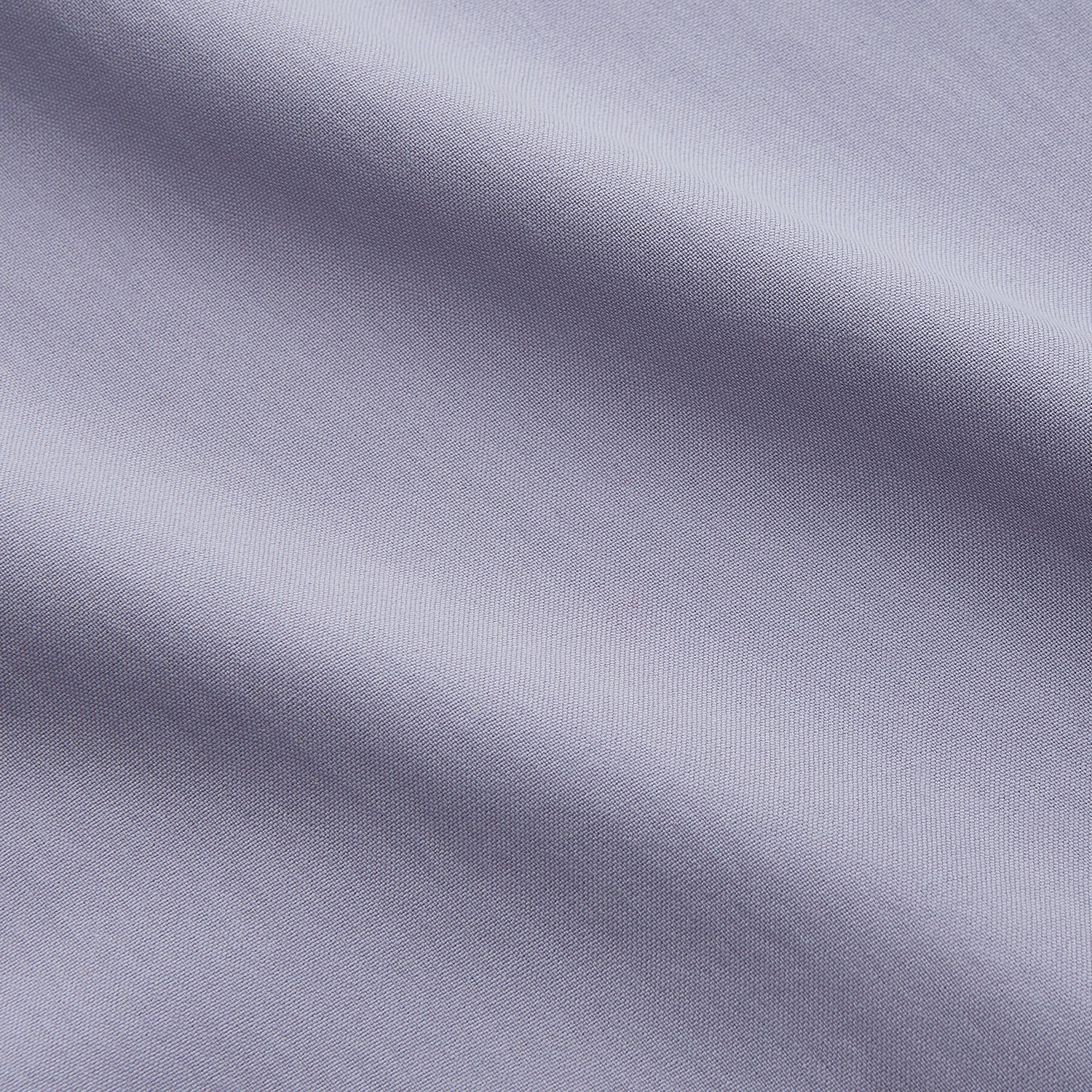 View 4 of product The Turnbull & Asser Lilac Silk Regular Fit Flaxton Shirt features long sleeves, a classic collar, white buttons, and a curved hem, shown laid flat on a white background.
