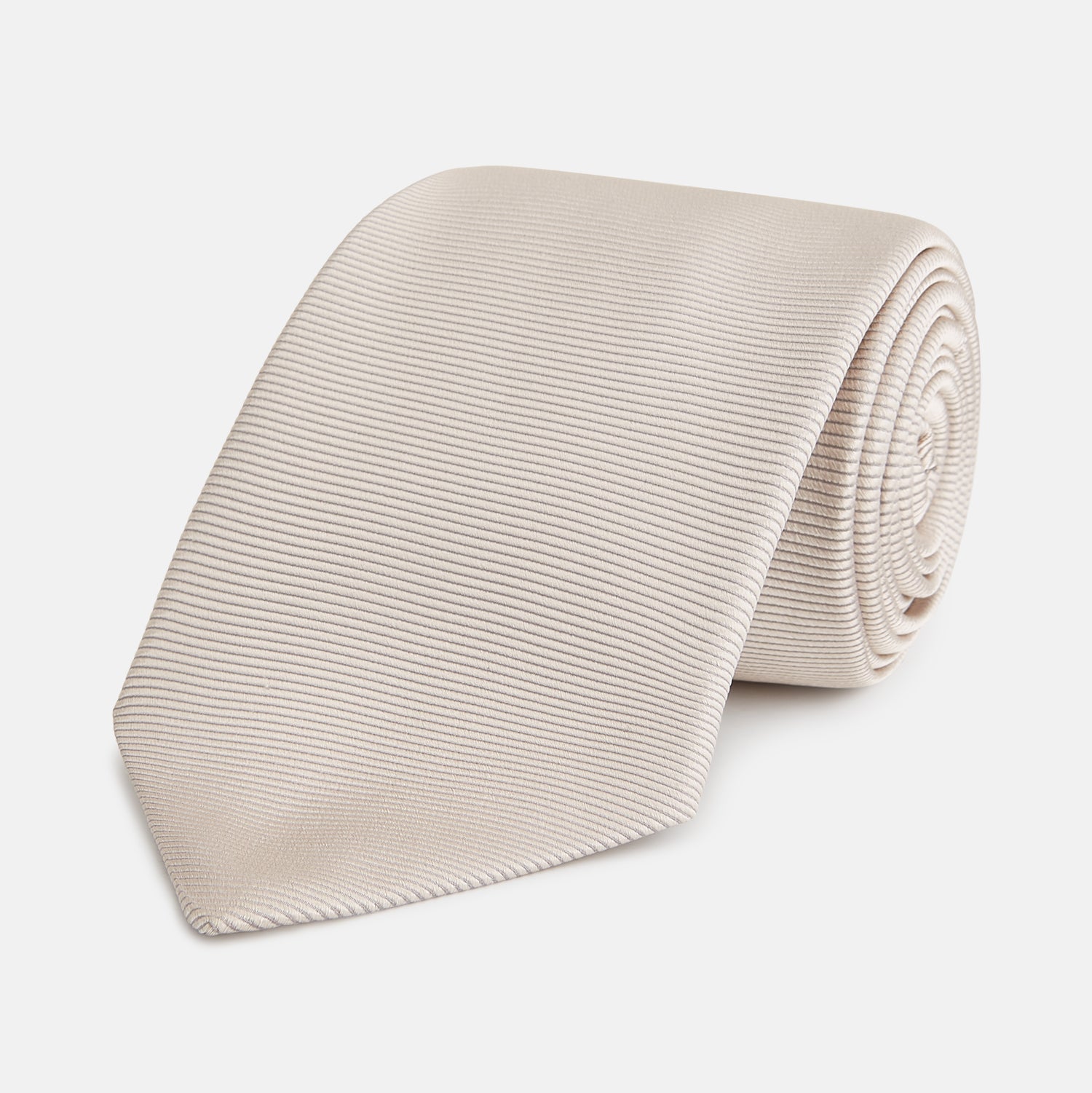 View 1 of product The Turnbull & Asser HORIZONTAL TWILL VELLUM TIE, a light beige silk necktie with a subtle ribbed texture, is shown rolled up on a white background—an essential finishing touch for smart attire.