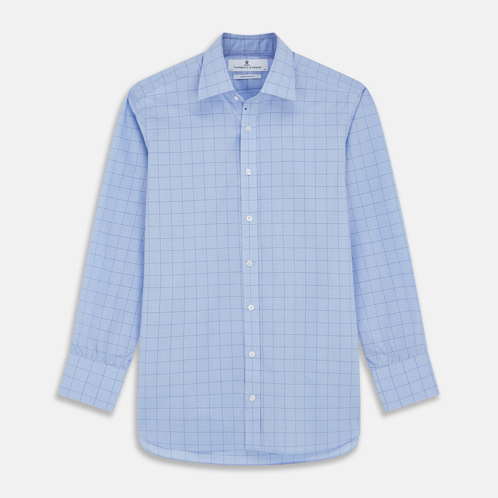 The Blue Prince of Wales Check Mayfair Shirt by Turnbull & Asser is a light blue formal long-sleeve shirt with a subtle check pattern, button-down front, and buttoned cuffs, shown laid flat on a white background.
