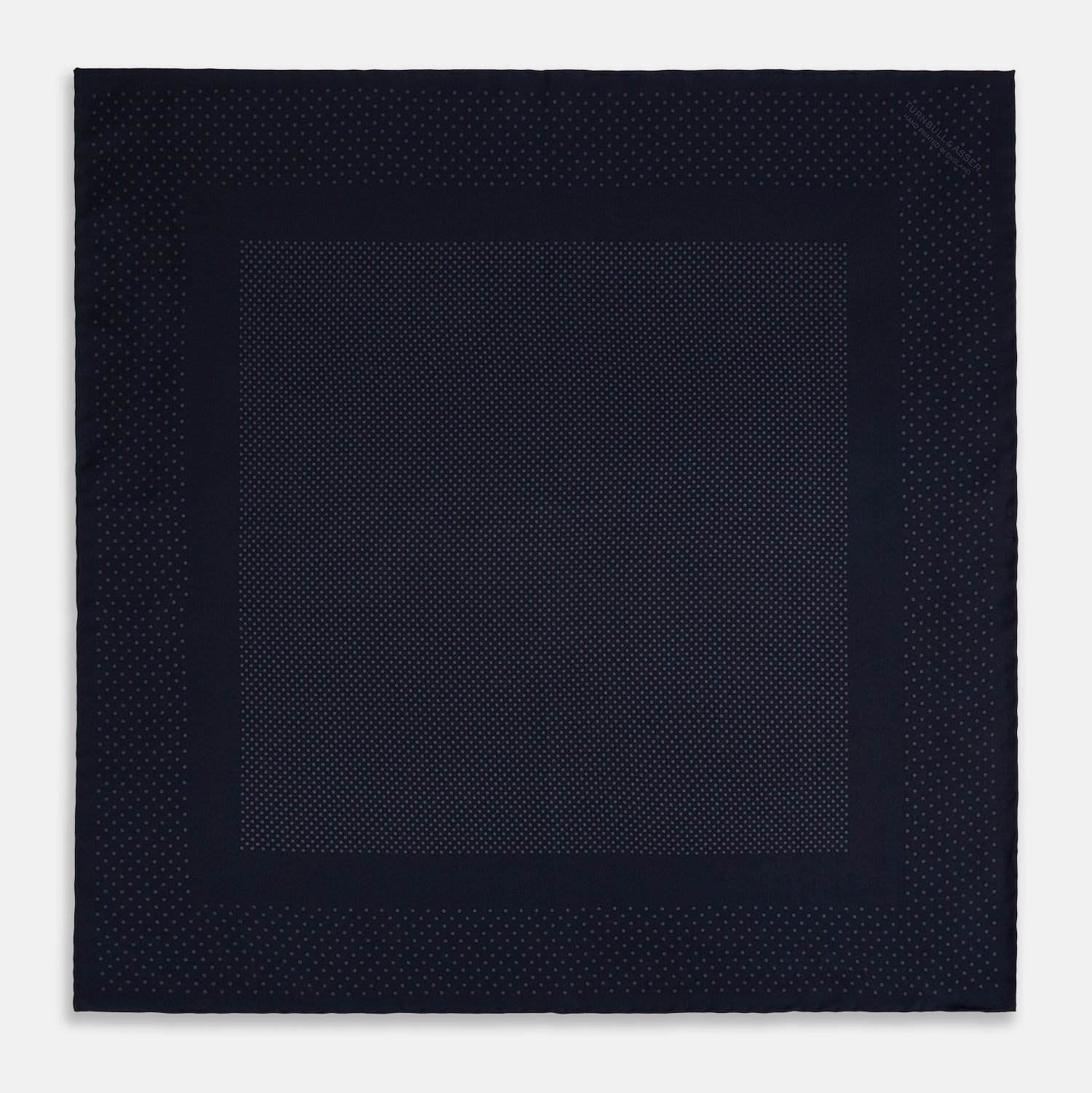 View 3 of product The Turnbull & Asser Navy and Charcoal Dot Silk Pocket Square features a subtle dotted pattern and a folded corner, shown on a white background.
