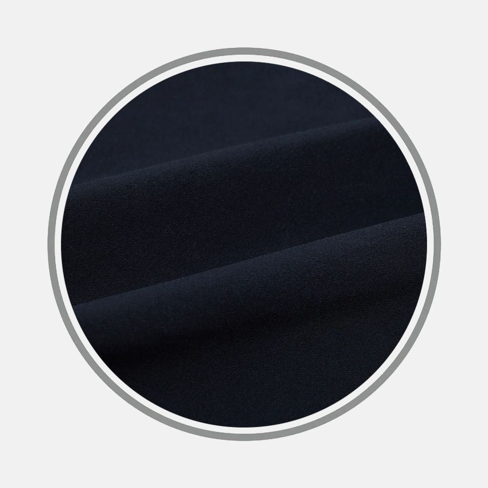 Close-up of Turnbull & Asser's Midnight Blue Fabric, showcasing its soft, smooth texture and deep navy hue, folded neatly inside a circular frame on a light gray background.