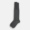 View 2 of product The Turnbull & Asser Steel/midnight Polka Dot Long Sock is shown in dark gray over the calf, displayed from the side on a white background with downward toe and ribbed top for a snug fit.