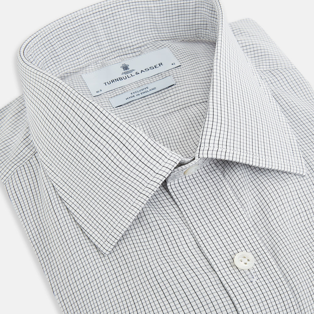 A tailored-fit Turnbull & Asser Mayfair Shirt in midnight blue with a grid check pattern, spread collar, and buttoned cuffs, crafted from premium Italian cotton and laid flat on a white background.