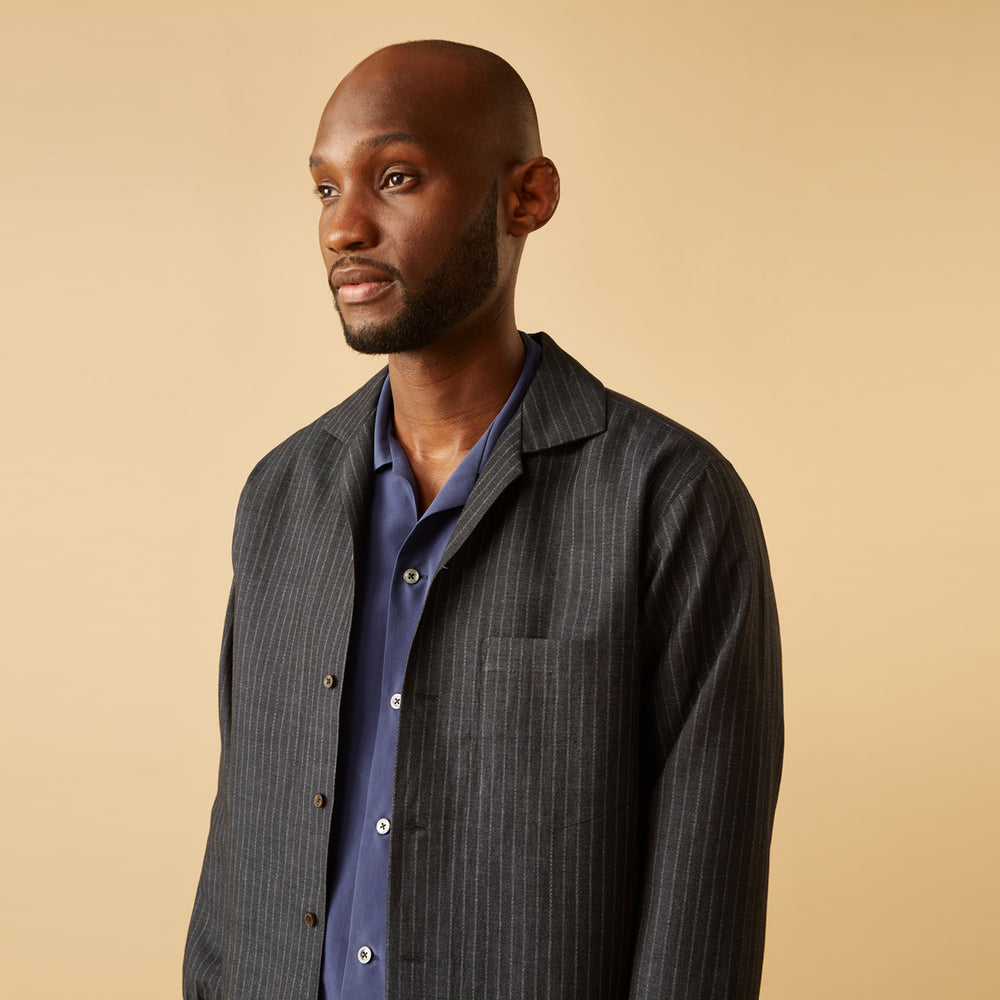 The Navy Tailored Pinstriped Shirt Jacket by Turnbull & Asser is a smart-casual, lightweight cotton-linen piece with long sleeves, a collar, left chest pocket, and front buttons for easy style.