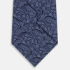 View 3 of product The Turnbull & Asser Navy Paisley Printed Silk Tie, featuring an intricate light lavender paisley design, is shown rolled up on a plain white background.