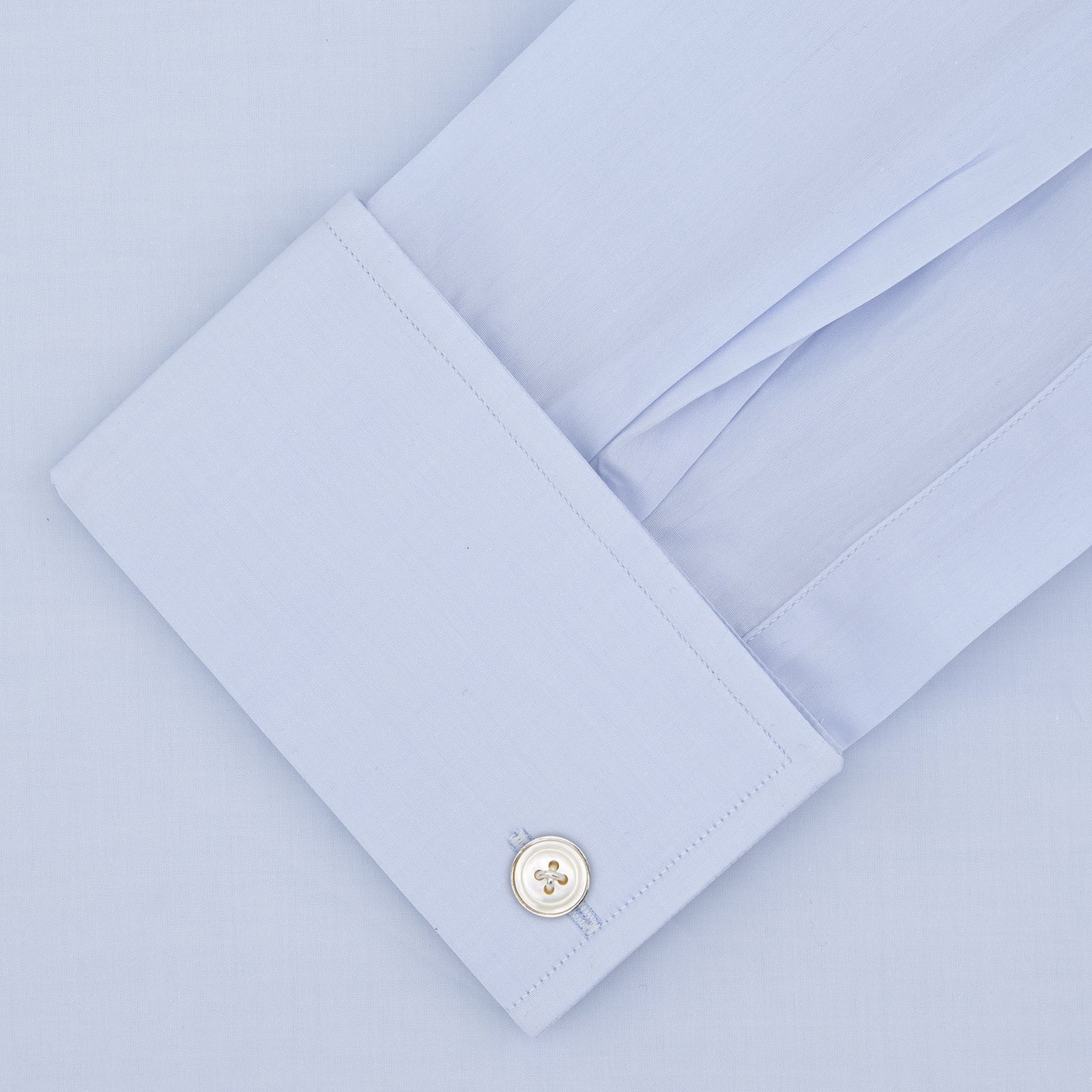 View 2 of product Displayed on a plain white background, the Turnbull & Asser Tailored Fit Two-Fold 120 Light Blue Cotton Shirt features a kent collar, double cuffs, and white buttons. The label inside highlights its Jermyn Street, London origin.