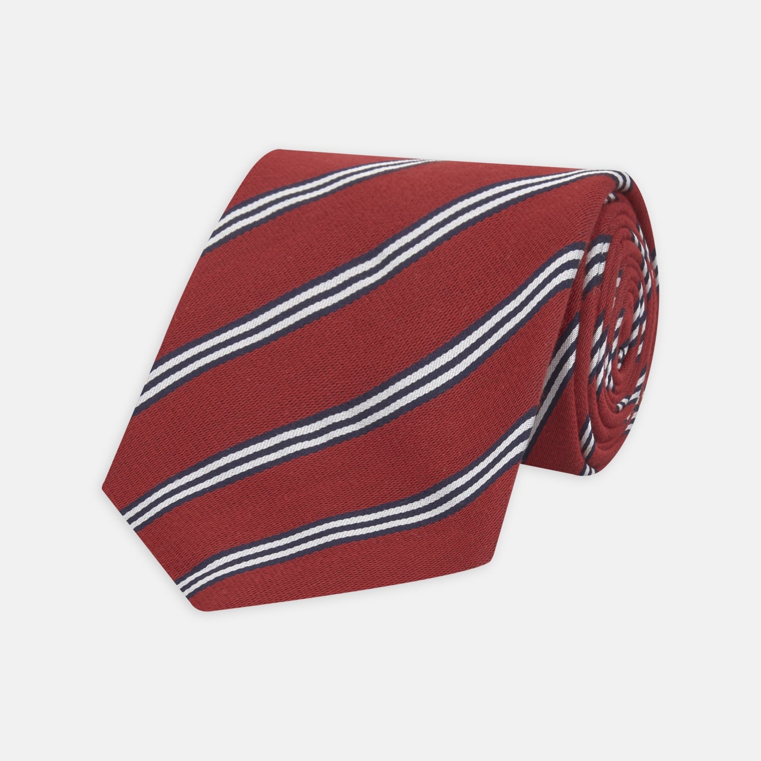 View 1 of product The Turnbull & Asser GGT92000 3042 48 OS is a rolled-up red cotton silk stripe tie with diagonal white and navy blue stripes, displayed on a plain white background.