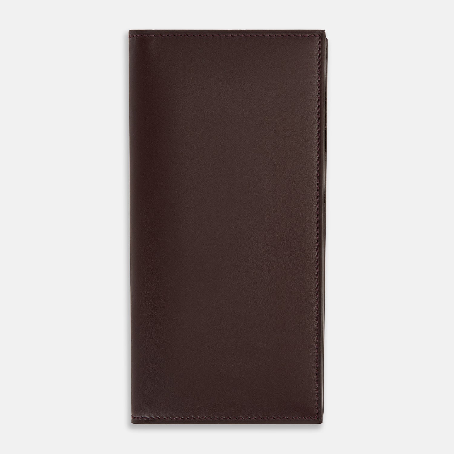View 1 of product The Turnbull & Asser Burgundy B Cut Continental Wallet, with smooth, unadorned surfaces and visible edge stitching, is pictured closed in rich burgundy Italian leather against a white background.