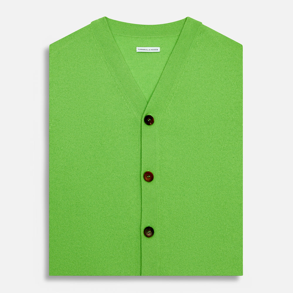 The Turnbull & Asser Lime Green Fine Merino V-Neck Sleeveless Cardigan features dark buttons, two front pockets, and a sophisticated look, all set against a plain white background.