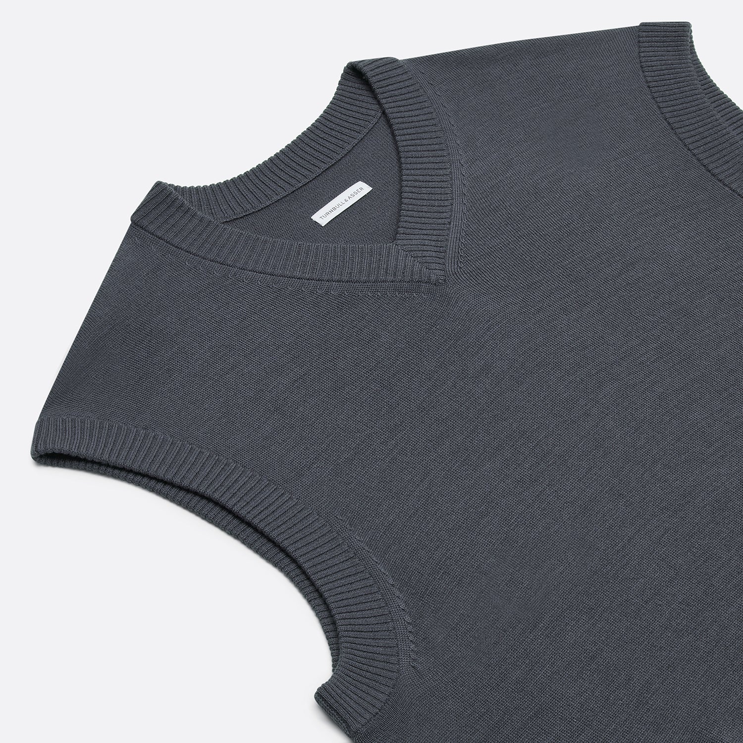 View 2 of product The Turnbull & Asser Grey Fine Merino V-Neck Vest, featuring a sleeveless design, is elegantly displayed against a plain white background.