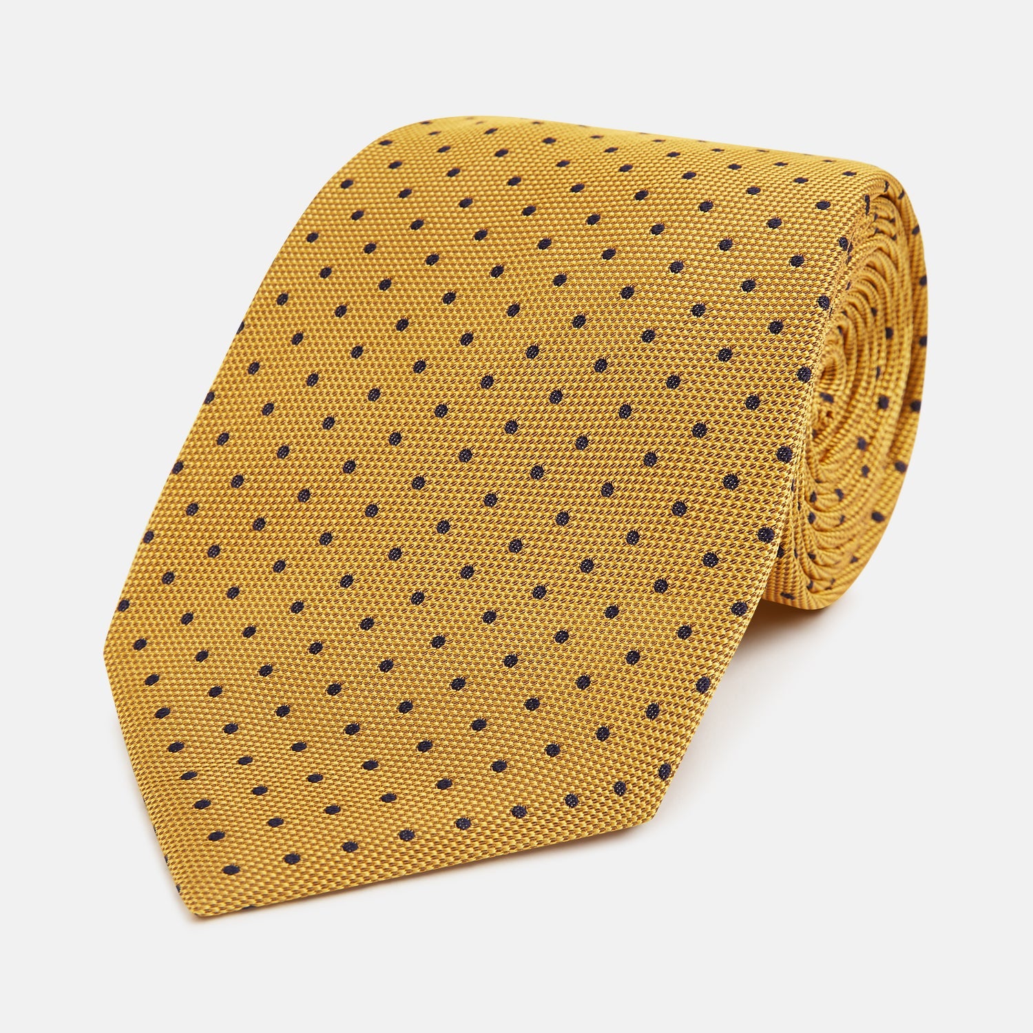 View 1 of product The Turnbull & Asser Navy and Yellow Micro Dot Silk Tie features evenly spaced dark blue micro dots on yellow silk, rolled and displayed on a white background—an elegant accessory for any occasion.