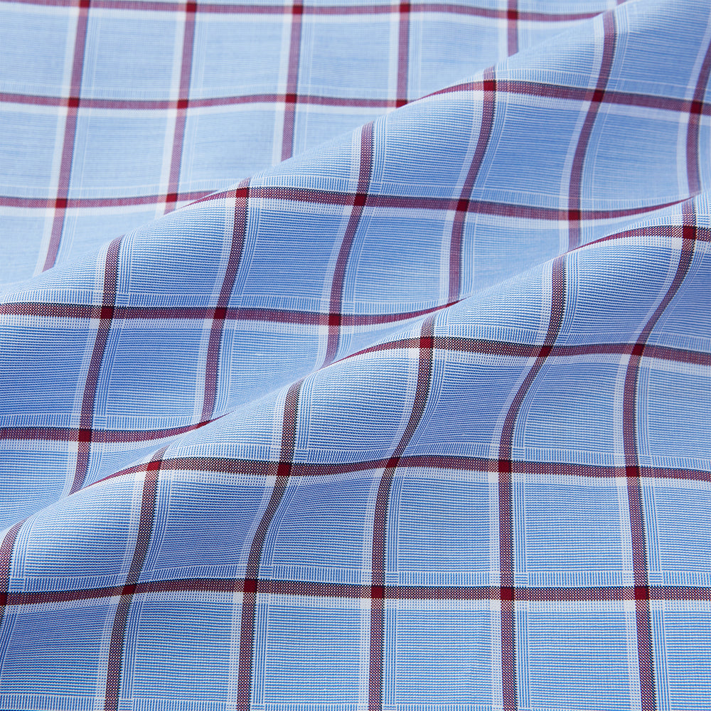 The Turnbull & Asser Blue and Burgundy Windowpane Mayfair Shirt features long sleeves, a light blue base with burgundy windowpane checks, a classic collar, and white buttons.