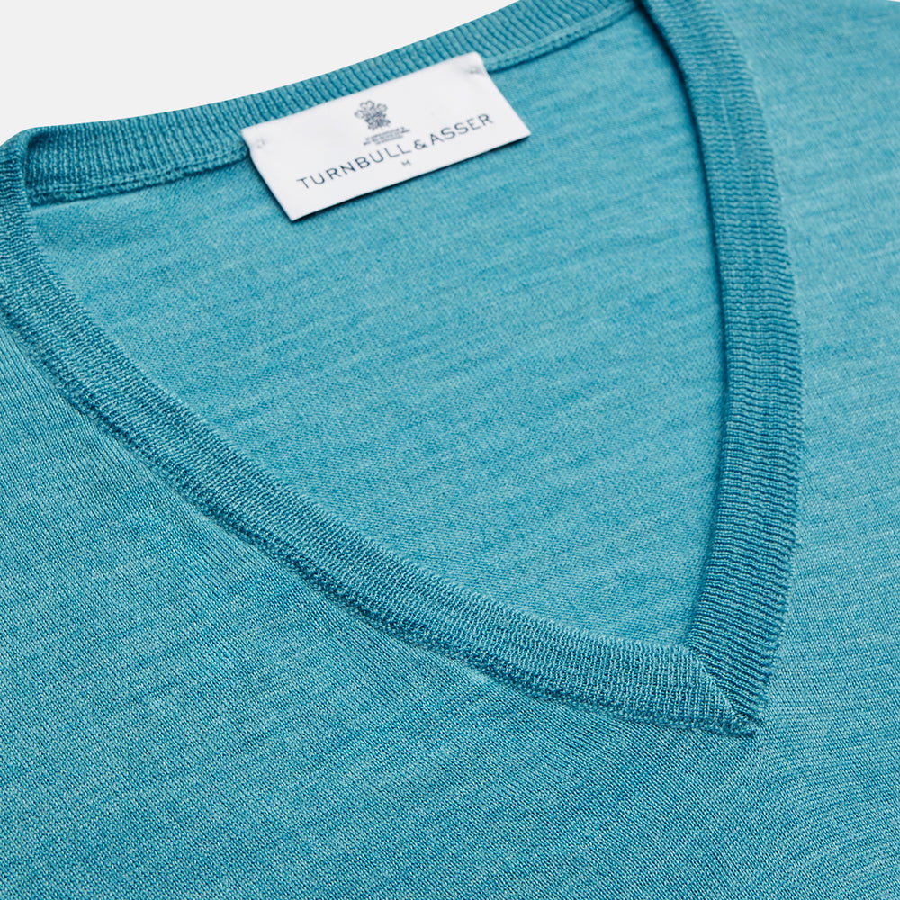 The Turquoise Kennedy Merino V-Neck Jumper by Turnbull & Asser features ribbed cuffs and hem, crafted from premium merino knitwear, and is shown flat on a white background.