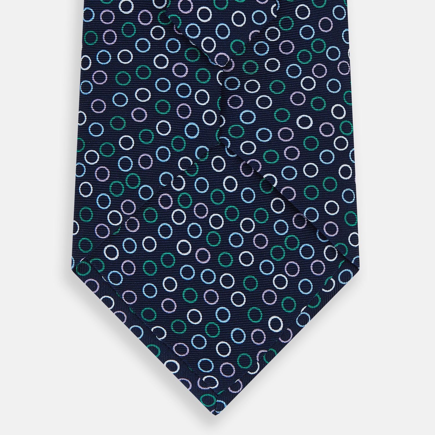 View 3 of product The Turnbull & Asser Green and Lilac Dark Navy Printed Silk Tie features a pattern of multicolored rings—an elegant formal accessory, shown rolled on a white background.