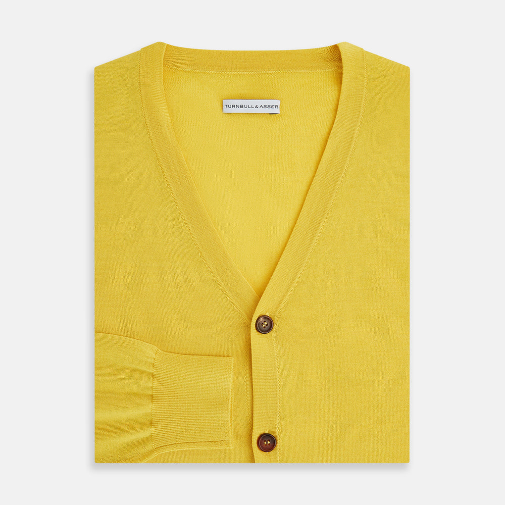 The Turnbull & Asser Canary Yellow Fine Merino V-Neck Cardigan features long sleeves, a button front with brown buttons, and ribbed cuffs and hem, displayed on a plain white background.