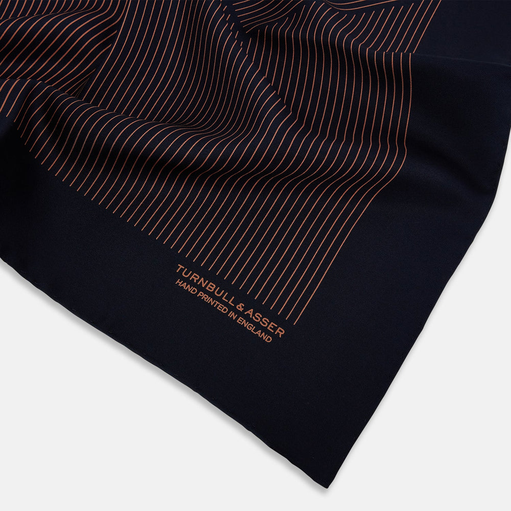 The Turnbull & Asser Navy and Blush Stripe Silk Pocket Square features thin blush stripes on navy silk, finished with "TURNBULL & ASSER HAND PRINTED IN ENGLAND" in the corner, highlighting its refined English craftsmanship.