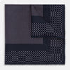 View 1 of product The Turnbull & Asser Navy and Lilac Dot Silk Pocket Square features small white polka dots with a wider border of spaced-out dots, neatly folded to showcase both sides of its handmade silk fabric.