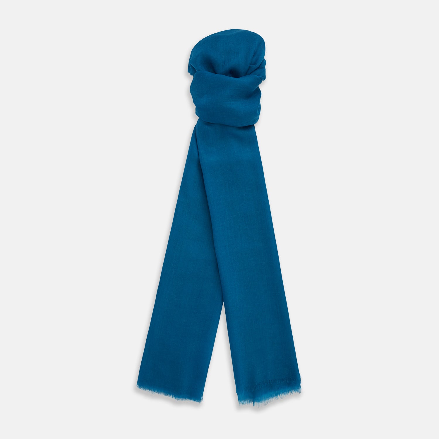 View 1 of product The Turnbull & Asser Steel Blue Cashmere Scarf, featuring a soft texture and slightly frayed edges, is neatly folded and tied in a loose knot against a white background.