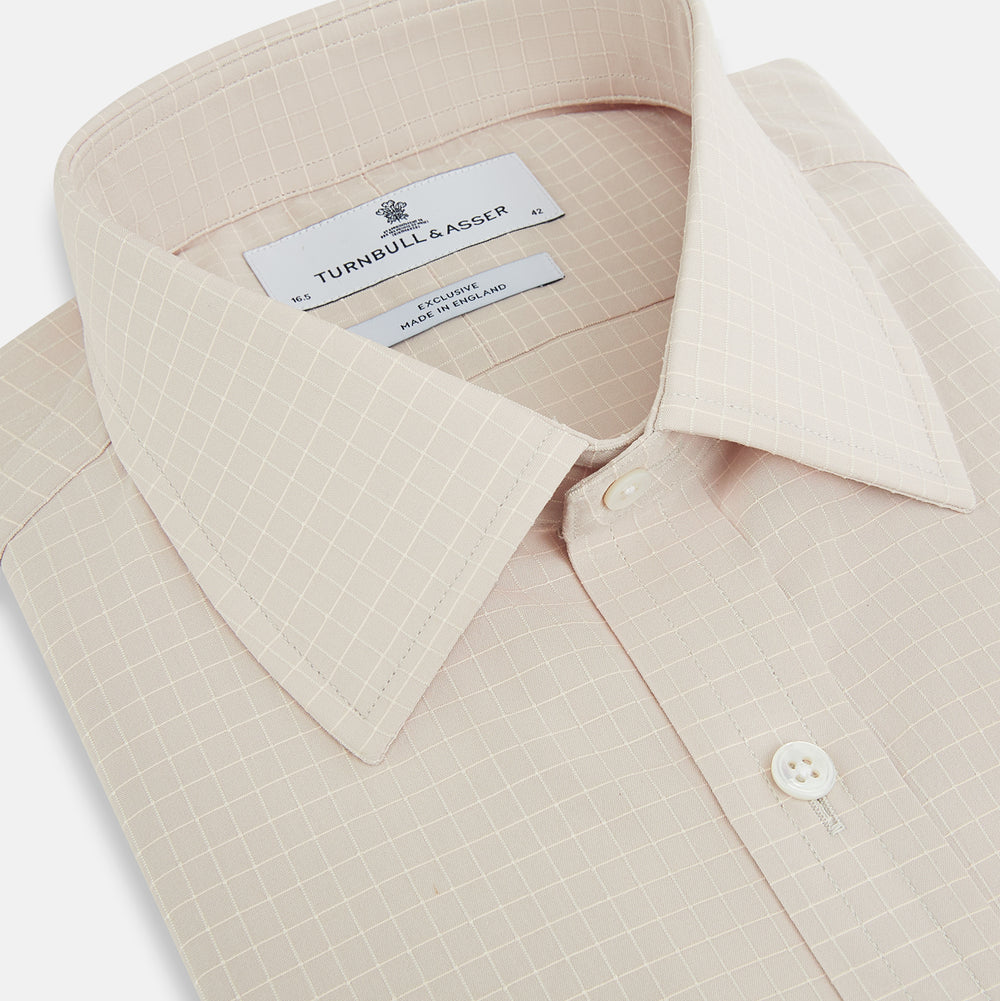 The Turnbull & Asser Pale Pink Fine Check Mayfair Shirt features long sleeves, a collared neckline, buttoned cuffs, and a subtle check pattern in sanforised cotton, displayed against a white background.