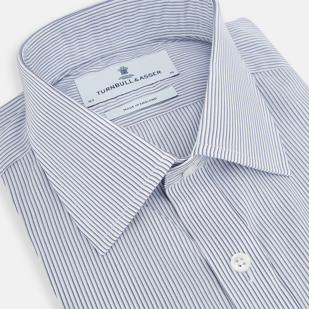 The Navy and White Ticking Stripe Mayfair Shirt by Turnbull & Asser features long sleeves, buttoned cuffs, a pointed T&A collar, and button-up front, shown on a plain white background.