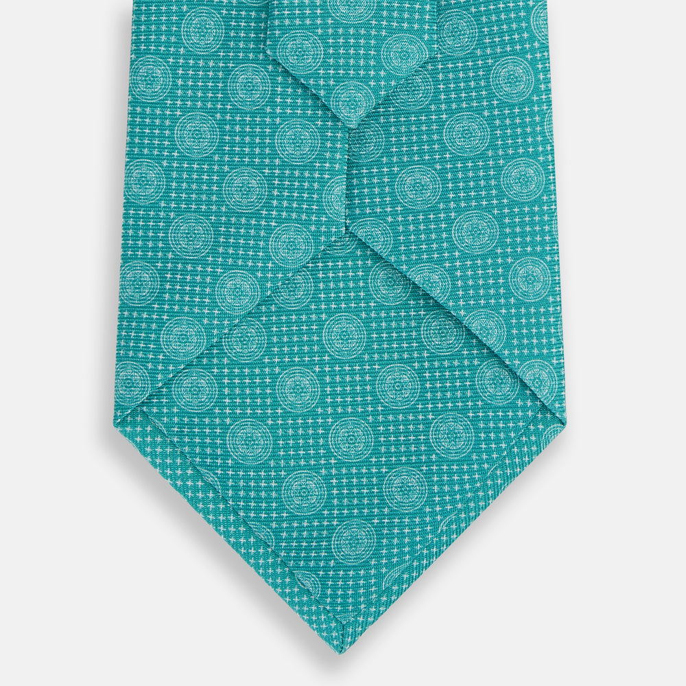 The Turquoise Medallion Silk Tie by Turnbull & Asser is crafted from fine English silk and features a repeating medallion pattern in lighter shades on turquoise.