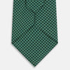 View 3 of product The Forest Green Geometric Floral Printed Silk Tie by Turnbull & Asser is shown rolled up on a white background, its English silk material featuring an elegant green and turquoise pattern.