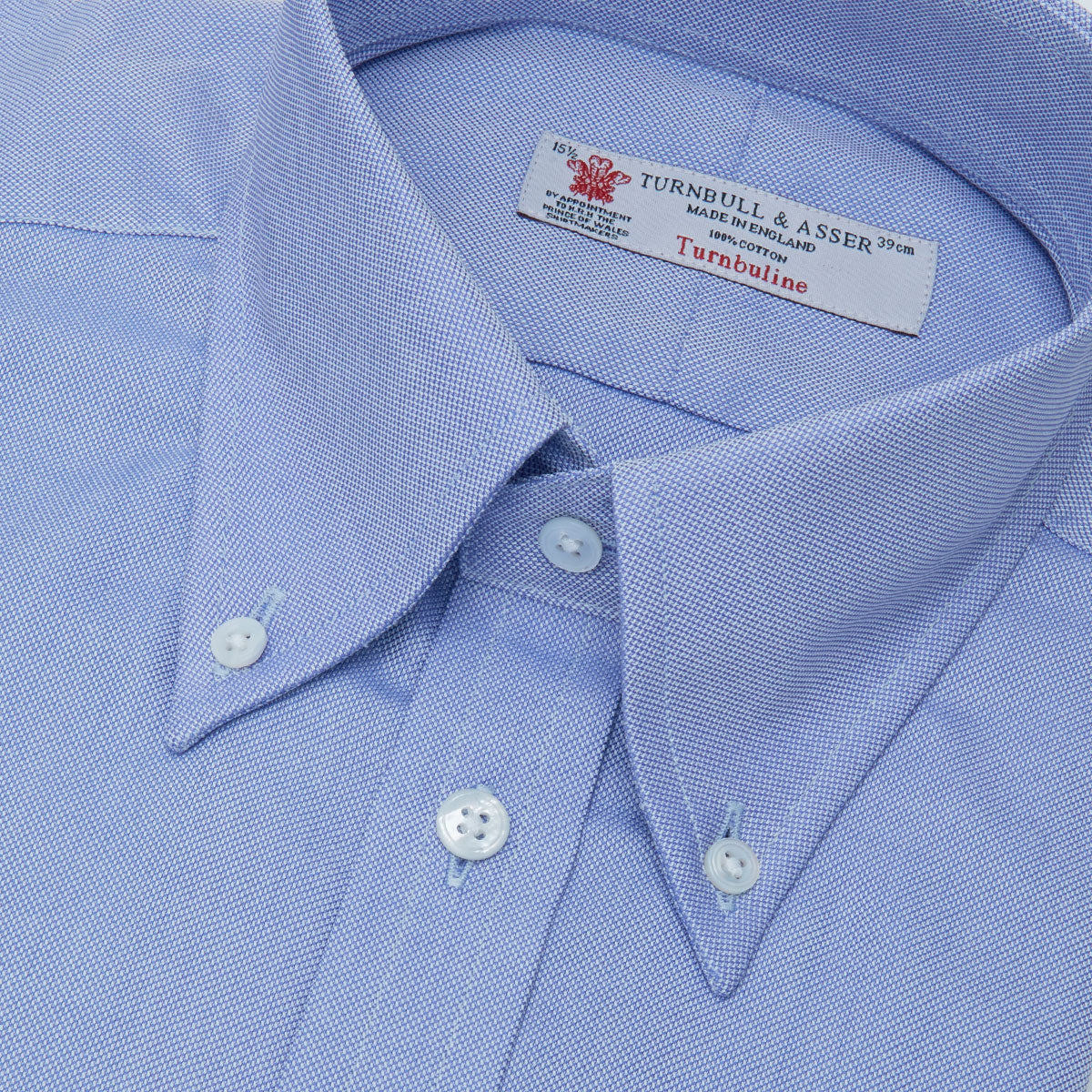 View 2 of product The Turnbull & Asser Blue Royal Oxford Cotton Shirt features a button-down collar, 3-button cuffs, and a visible brand label, shown neatly folded on a white background—ideal for pairing with a navy suit.