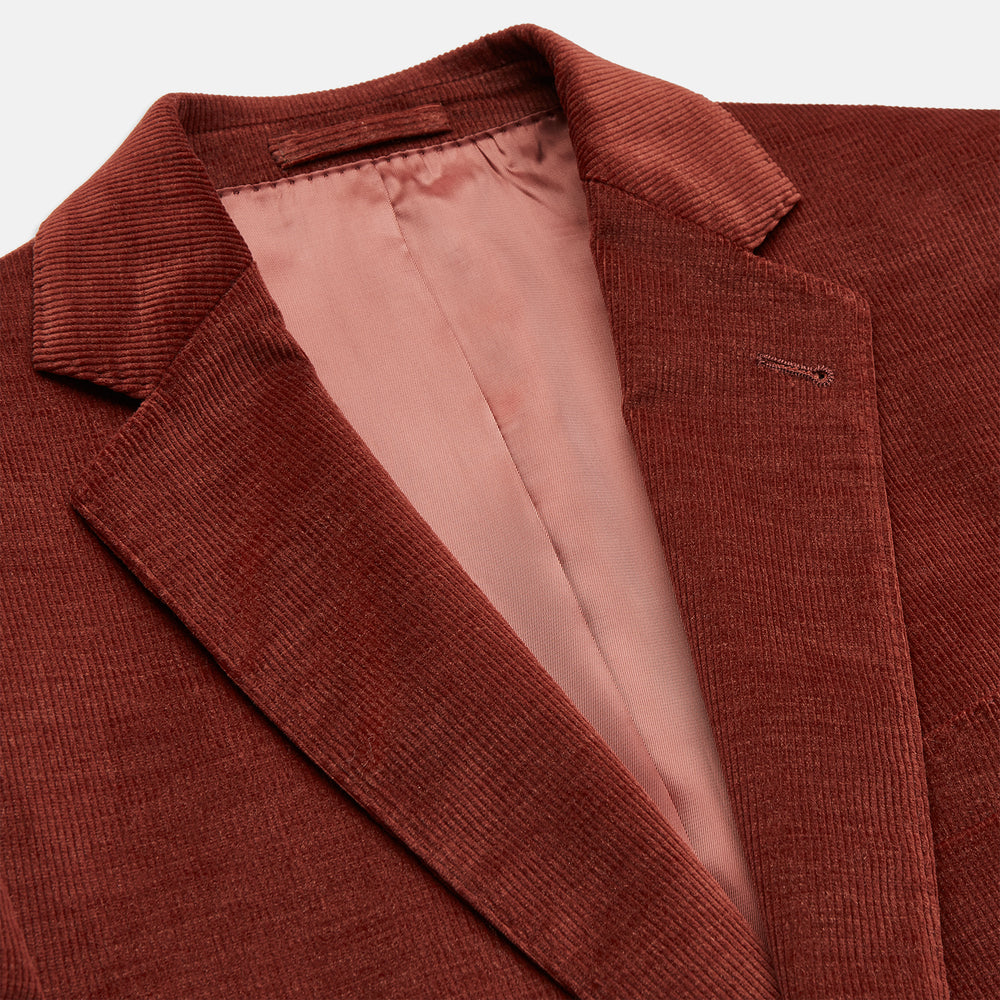 The Rust Cord Barrington Blazer by Turnbull & Asser is tailored in Italy with notch lapels, two front buttons, three pockets, and four-button cuffs, shown flat on a white background.