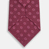 View 3 of product The Turnbull & Asser Burgundy Medallion Printed Silk Tie features small circular medallions and subtle light pink diagonal lines, crafted from fine English silk and displayed on a plain white background.