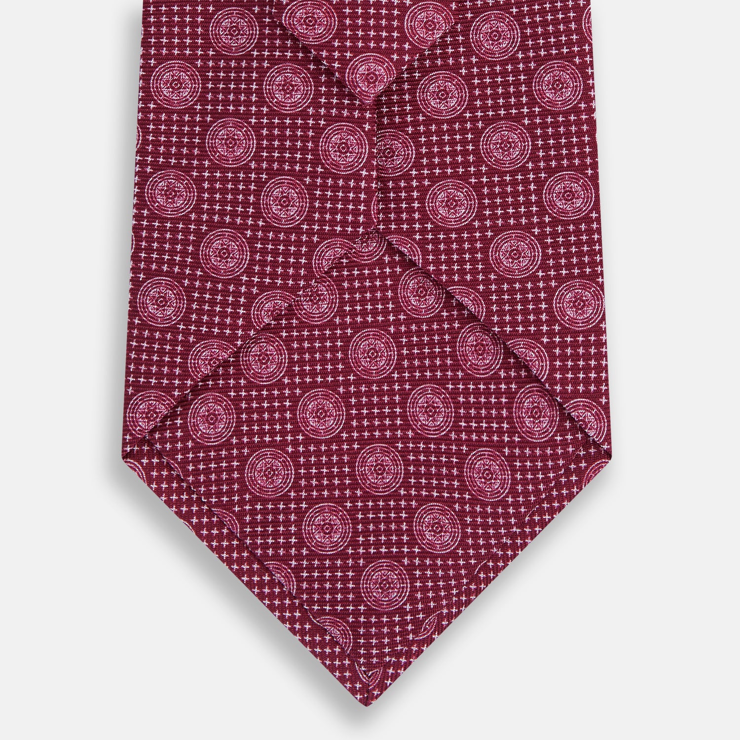 View 3 of product The Turnbull & Asser Burgundy Medallion Printed Silk Tie features small circular medallions and subtle light pink diagonal lines, crafted from fine English silk and displayed on a plain white background.