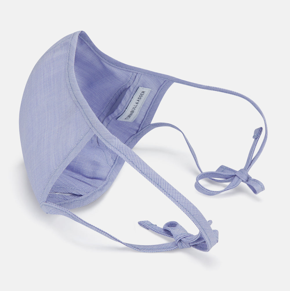 The Turnbull & Asser Plain Pale Blue Commuter Mask with 3 Viroformula™ filters features adjustable ear loops and side ties—ideal for daily use, shown against a white background.