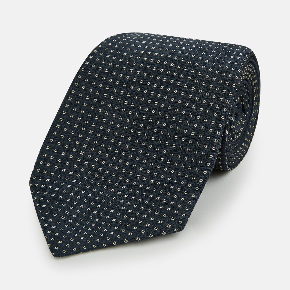 The Navy and White Square Silk Tie by Turnbull & Asser is crafted from English silk with a subtle white square pattern, rolled tip-forward and displayed on a white background for a tailored look.