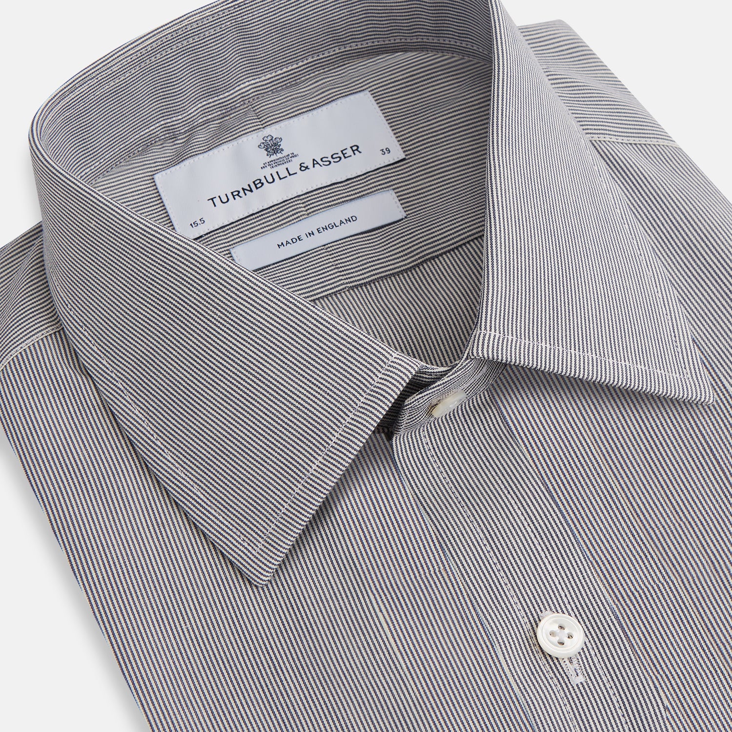 View 2 of product The Turnbull & Asser Navy Fine Stripe Mayfair Shirt, a long-sleeve, button-up with a classic collar, features fine navy stripes and white buttons, shown laid flat on a white background.