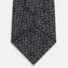 View 3 of product The Turnbull & Asser Navy Paisley Foulard Silk Tie features a refined paisley pattern in blue, white, and beige tones, elegantly rolled and presented against a white background.