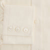 View 4 of product The Cream Fine Pencil Stripe Mayfair Shirt by Turnbull & Asser features long sleeves, a pointed collar, and buttoned cuffs. Crafted from breathable cotton with fine pencil stripes, it is shown laid flat on a white background.