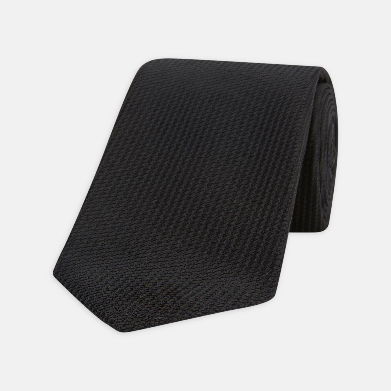 View 1 of product Turnbull & Asser's Seven-Fold Black Lace Silk Tie, featuring a textured finish and pointed tip, is elegantly rolled and displayed on a white background—a timeless accessory for any luxury neckwear collection.