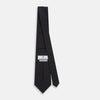 View 4 of product The Turnbull & Asser Teal and Navy Circle Silk Tie features a subtle herringbone pattern with small repeating circle motifs, displayed neatly rolled on a white background.