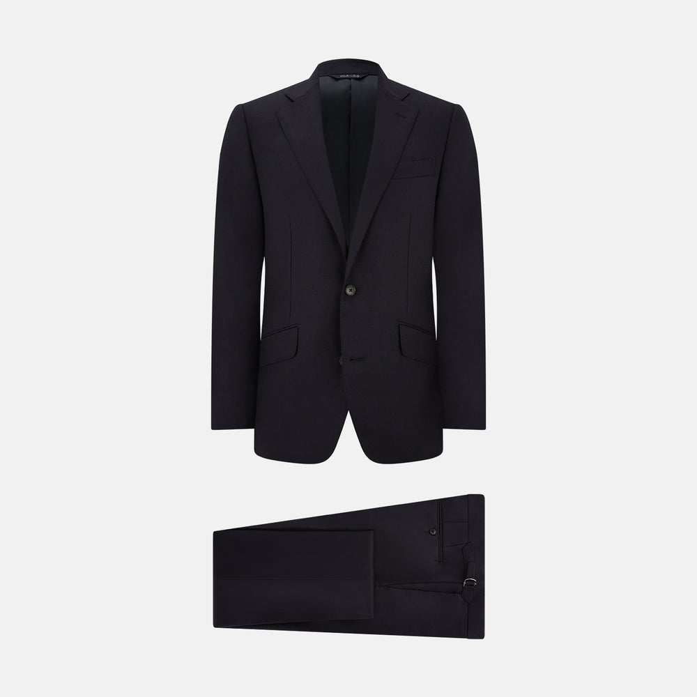 The Turnbull & Asser Short Navy Single Breasted Suit is shown flat on a white background, with a notch lapel jacket featuring two front pockets and matching trousers neatly folded underneath.