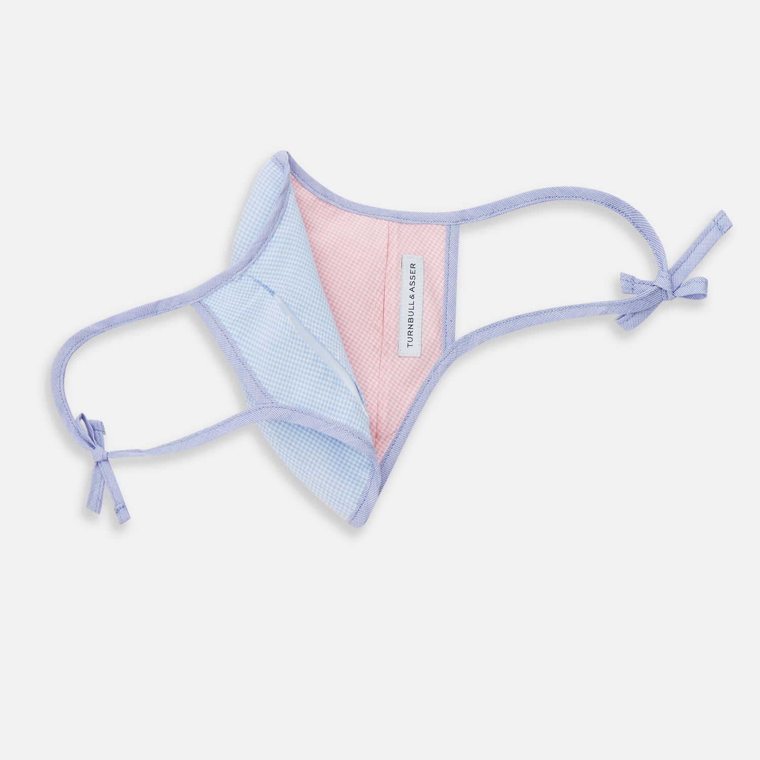 View 5 of product The Turnbull & Asser Pink & Blue Check Commuter Mask features lavender adjustable ear loops tied in bows and comes with 3 Viroformula™ filters. Shown on a plain white background.