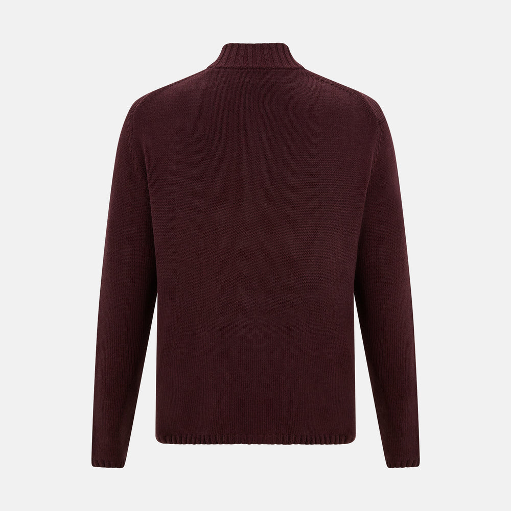 The Turnbull & Asser Burgundy Merino High Neck Zipped Cardigan features long sleeves, a zip-up front, and ribbed collar, cuffs, and hem, crafted from soft merino knitwear and shown on a white background.