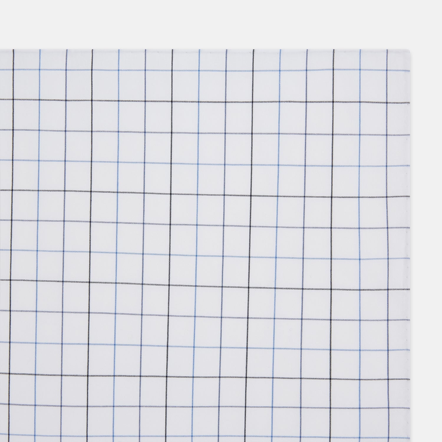 View 2 of product The Turnbull & Asser Hand Rolled Blue Grid Check Handkerchief features a classic blue and black grid on white cotton, neatly folded—a timeless gentleman's accessory.