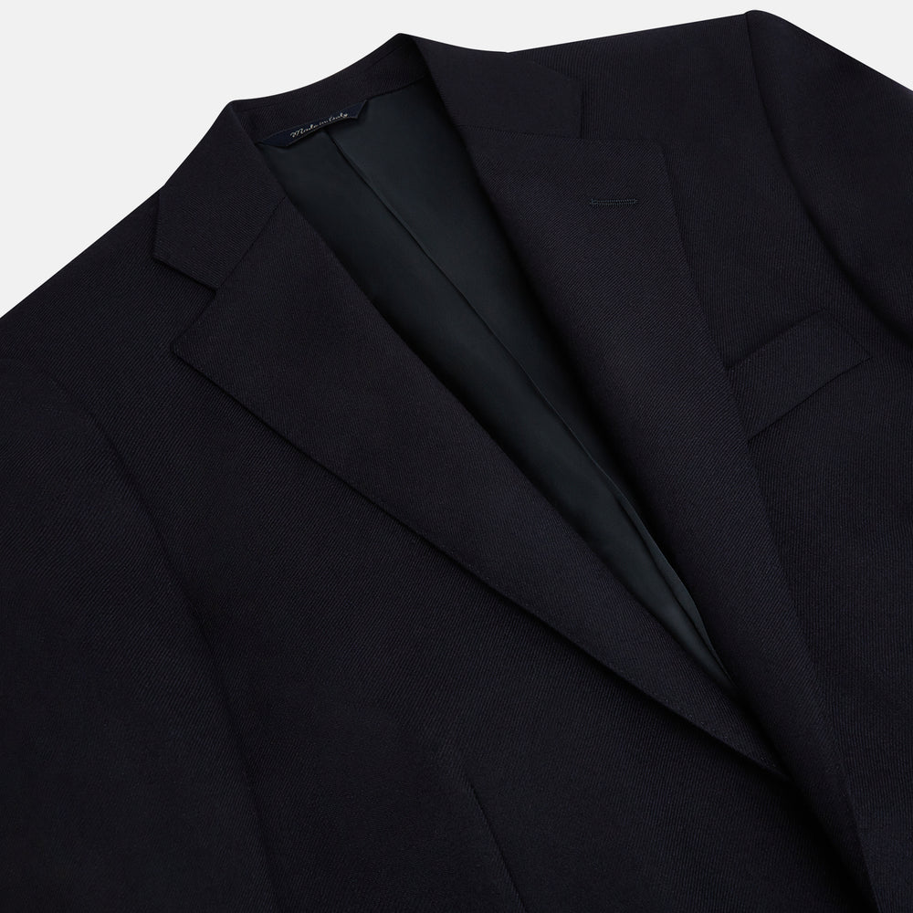 The Turnbull & Asser Long Navy Single Breasted Classic Blazer features British tailoring with two gold buttons, notched lapels, and three front pockets, shown on a plain white background.