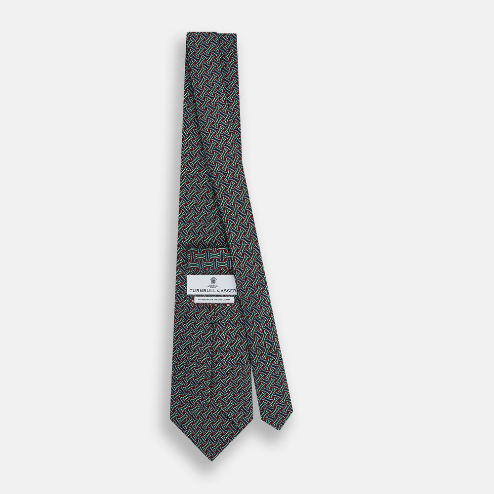 The Forest Green and Red Weave-Patterned Printed Silk Tie by Turnbull & Asser features an intricate geometric motif in red, green, blue, and white, crafted from luxurious English silk for classic sophistication.