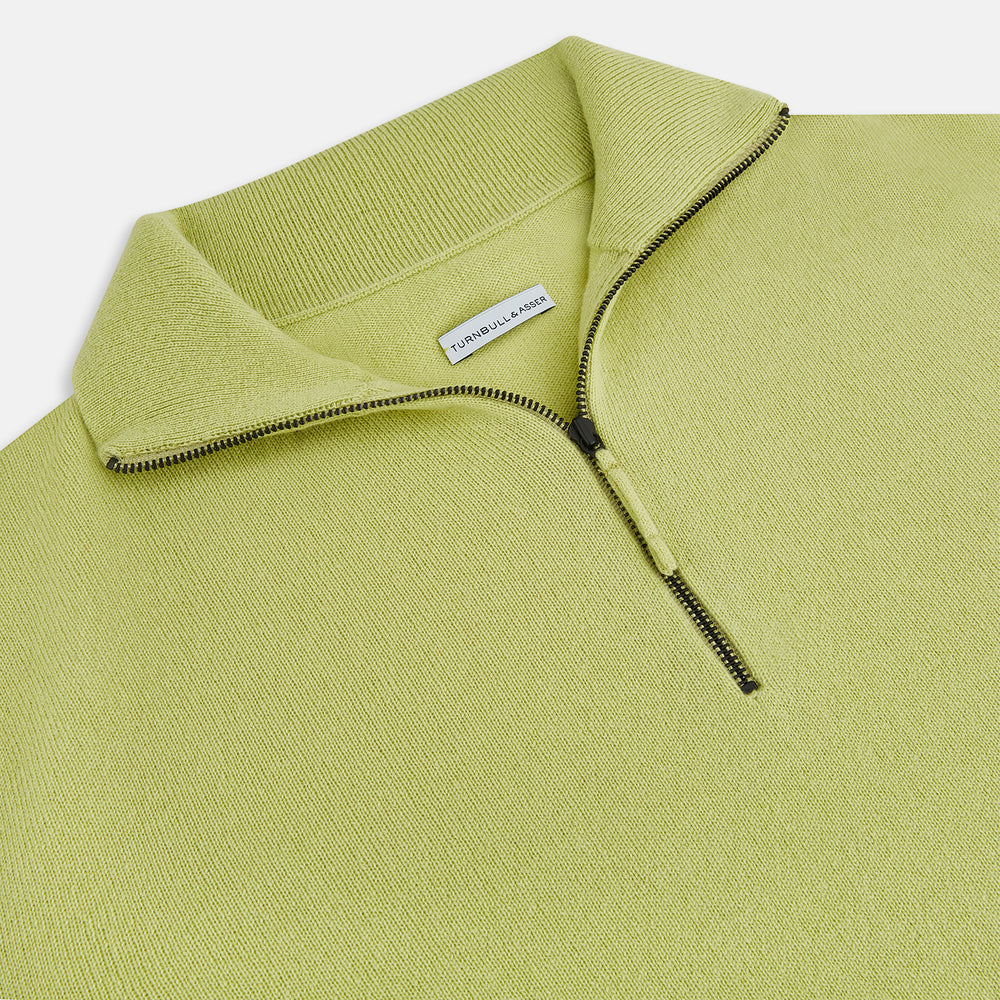 The Turnbull & Asser Melon Green Half-Zip Cashmere Jumper features long sleeves, a high collar, and half-zip front—ideal knitwear for layering. Shown on a plain white background.