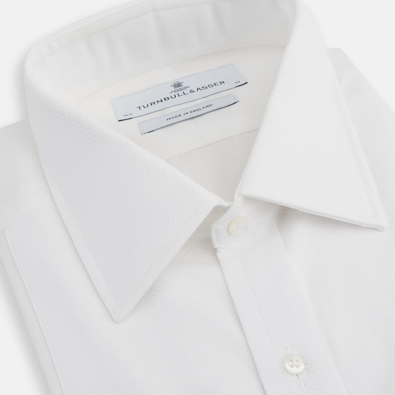 View 2 of product The Turnbull & Asser White Marcella Dress Shirt features a T&A collar, double cuffs, and pleated front detailing—ideal for formal occasions. Displayed on a plain white background.