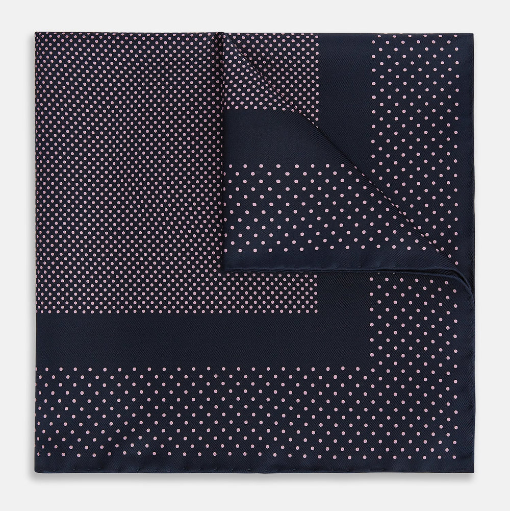 The Turnbull & Asser Navy and Pink Dot Silk Pocket Square features small pink dots and a solid border, with one corner folded to display both sides—an elegant accessory that reflects fine handmade craftsmanship.