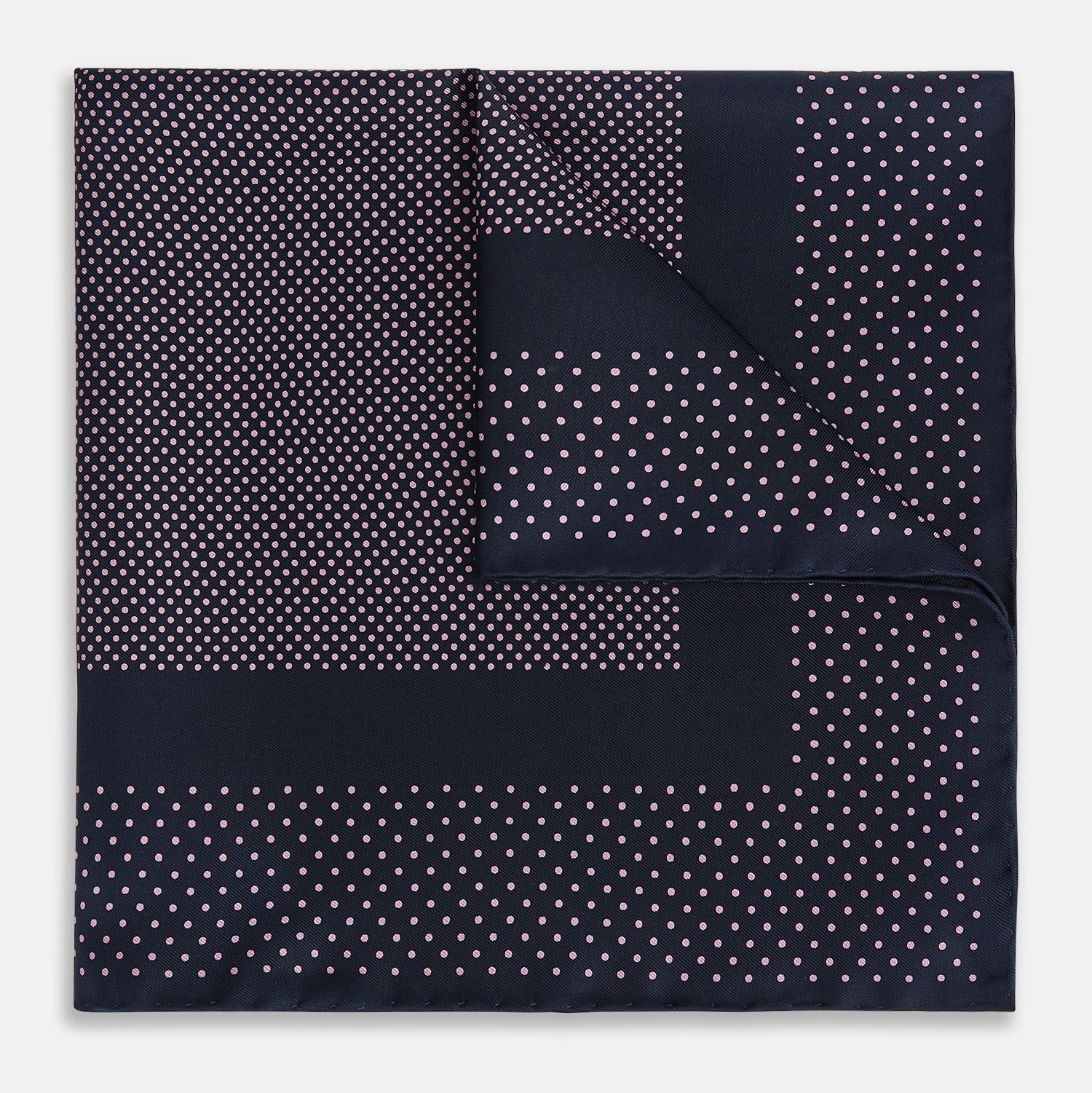 View 1 of product The Turnbull & Asser Navy and Pink Dot Silk Pocket Square features small pink dots and a solid border, with one corner folded to display both sides—an elegant accessory that reflects fine handmade craftsmanship.