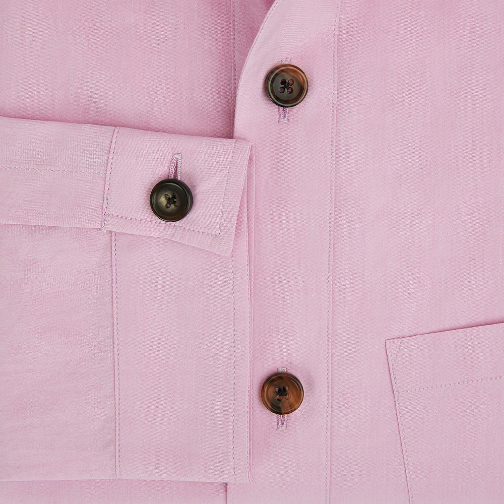 The Pink Hyde Overshirt by Turnbull & Asser is a long-sleeved, light pink sanforised cotton shirt with a left chest pocket and dark buttons—an elegant, laid-back alternative to a blazer.